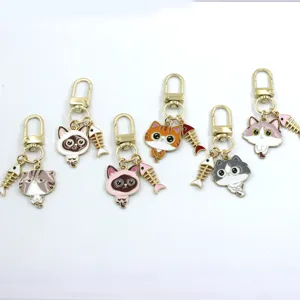 Detailed close-up showing cute alloy cat keychains with mini fish bone pendants for bags.