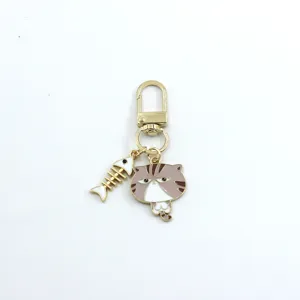 Cute alloy cat and fish bone keychain pendant, golden metal finish, bag charm detail.