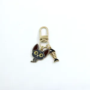 Close-up detail shot of the cute alloy cat head and fish bone charm keychain pendant accessory.