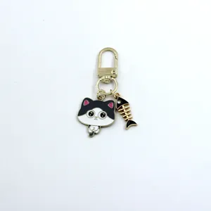 Close-up detail of the cute black and white cat alloy keychain with fish bone pendant.