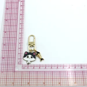 Cute alloy cat and fish bone keychain detail shot, compact metal pendant accessory.