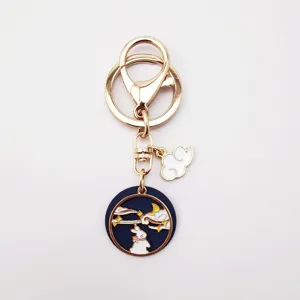 Close-up detail of the metal alloy moon rabbit keychain featuring enamel drops and golden ring.