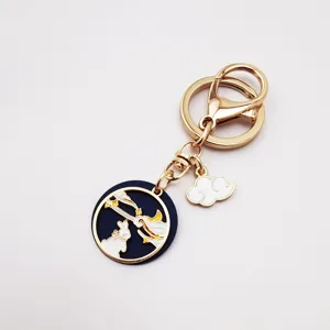 Gold alloy keychain detail view with dark blue enamel rabbit charm and gold clasp.