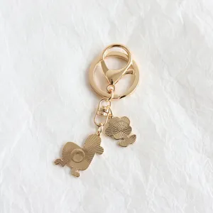Gedetailleerd eend en bloem metalen sleutelhanger detailweergave, gouden tas hanger.
