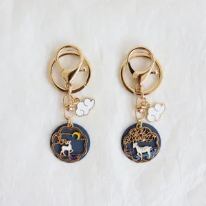 Detailed view of gold alloy enamel deer keychains with white cloud charms for bags and keys.