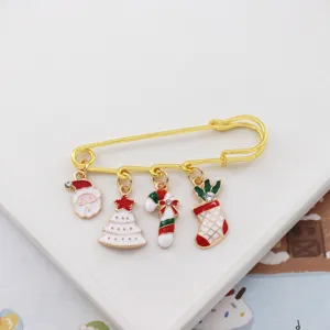 Christmas safety pin brooch with Santa tree candy cane and stocking charms for decor.