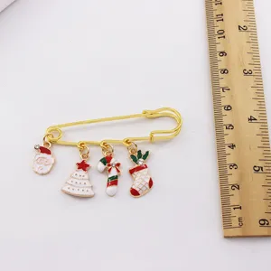 Close-up detail shot of a cute Christmas alloy brooch with charms and a sizing ruler.