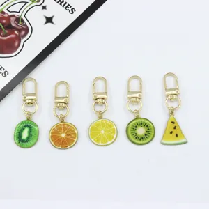 Fruit slice alloy keychain detail showing cute kiwi, orange, lemon and watermelon pendants.