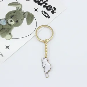 Cute lying cat keychain, gold metal charm pendant for bags and car keys. Detailed view.