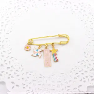 Close-up detail of a gold-plated inspirational exam blessing brooch with colorful enamel charms.