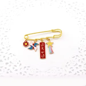Gold safety pin brooch with cute enamel charms like pinwheel and blessing tag for students.