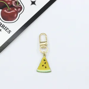 Detail view of a cute yellow watermelon slice alloy keychain charm, perfect for bags and keys.