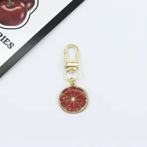 Gold-tone alloy metal keychain featuring a red citrus fruit slice pendant for bags.