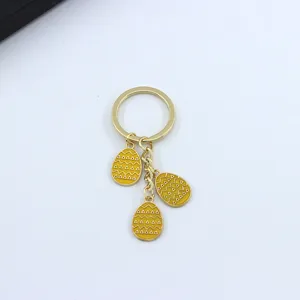Close-up detail of the Easter egg metal keychain with yellow enamel and triangle patterns.