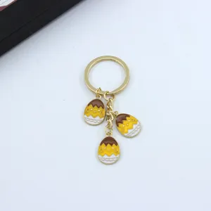 Close-up detail of the cute Easter chick keyring with vibrant enamel egg charms on gold chain.