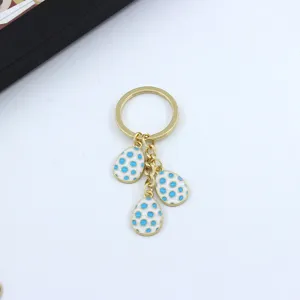 Metal keychain featuring three white and blue dot easter egg charms for women and bags.