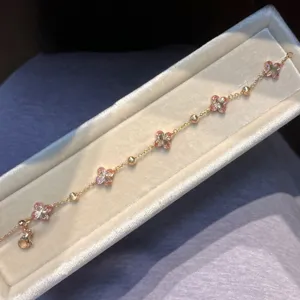 Closeup of gold flower bracelet with colorful zircon, elegant detail view of luxury jewelry.