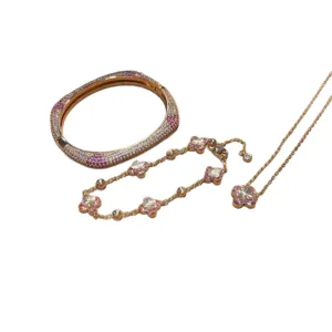 Elegant gold jewelry set featuring a gradient zircon flower necklace, bracelet and bangle.