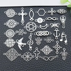Detailed view of assorted antique silver DIY jewelry findings, charms, and metal connectors.