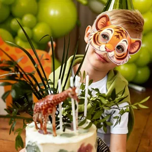 Niño con una máscara de tigre de dibujos animados en fiesta, detalle tema selva.