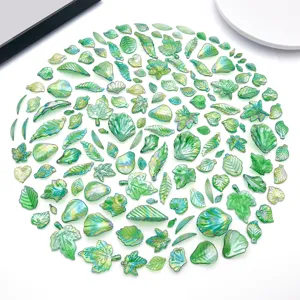 Close-up of assorted iridescent green acrylic leaf beads for DIY jewelry making and earrings design.