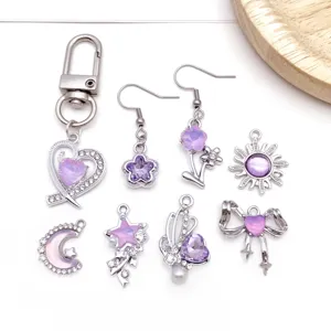 Close-up of DIY alloy purple crystal jewelry charms, cute heart star bow pendants for crafting.