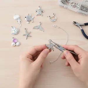 Detalle de fabricación de joyería DIY de mar con dijes de estrella de mar y cadena.