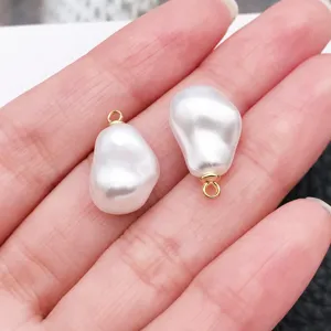 Close-up of baroque irregular white pearl pendant with gold bail for DIY jewelry making detail.