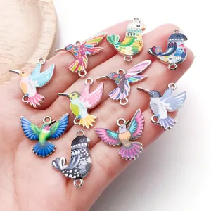 Close-up of colorful enamel hummingbird charms, DIY alloy metal pendant for bracelet making.