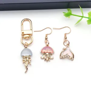 Detailed shot of gold-tone jellyfish keychain and crystal fish tail earrings DIY jewelry accessories.