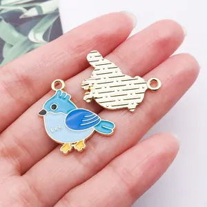 Close-up detail of cute blue bird enamel charm pendant, KC gold finish, DIY jewelry making.
