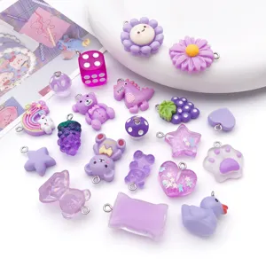 Dettaglio di ciondoli in resina viola e accessori fai-da-te, con piccoli orsetti, stelle e pendenti.
