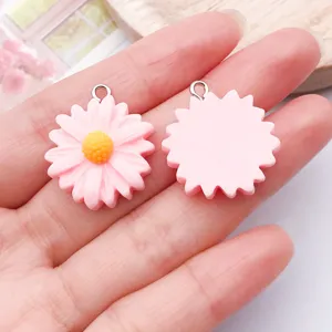 Detailopname van roze madeliefje hars bedels met metalen oogje, perfect voor DIY sieraden.