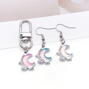 Detailansicht des irisierenden Harz-Mond-Anhängers und passender Ohrringe mit Strass.