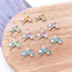 Detail shot of colorful gradient enamel mermaid tail charms with pearl and crystal for DIY crafts.