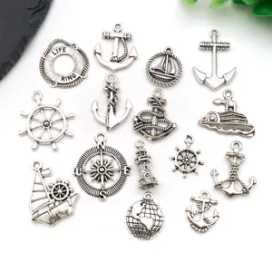 Detailed view of vintage silver nautical charms, anchor and ship wheel pendants for DIY jewelry.