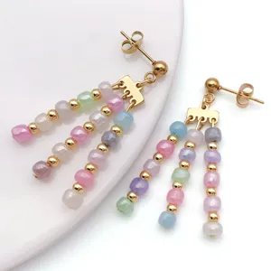 Detailed view of pastel beaded dangle earrings featuring colorful charms and gold tone posts.