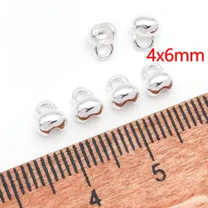 Vista detallada de pequeños ganchos para colgantes de metal con regla para joyería.
