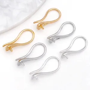 Close-up detail of metal DIY earring hooks with pin settings in gold and silver colors.