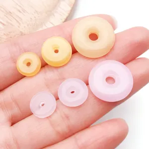 Close-up of colorful imitation jade donut beads in assorted sizes for DIY jewelry making.