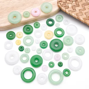 Close-up details of assorted glass jade-like donut beads in various colors for DIY jewelry crafts.