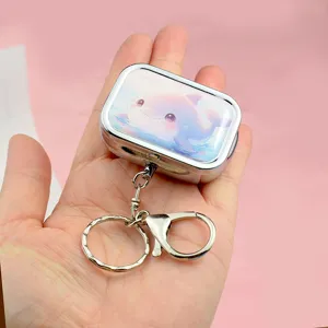 Metal pill box keychain with cute pink dolphin print, portable storage box detail view.
