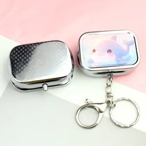 Metal pill box storage case and cute dolphin keychain pendant close-up detail view.