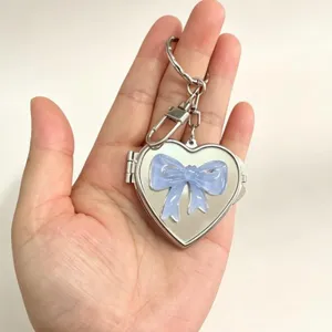 Silver heart shaped mirror keychain with cute blue bow, stylish bag charm and keyring pendant.