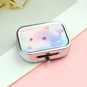 Portable rectangular metal pill box with cute cartoon dolphin pattern for daily storage.