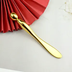 Gouden metalen oogcrème massagestick lepel hulpmiddel voor gezichtsverzorging en oogruimte.