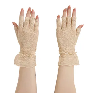 Detailansicht eleganter Damen Spitzenhandschuhe in Beige ohne Finger mit Rüschen am Handgelenk.