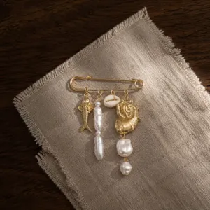 Broche épingle dorée style océan avec perle artificielle, poisson et coquillage. Bijou de vacances.