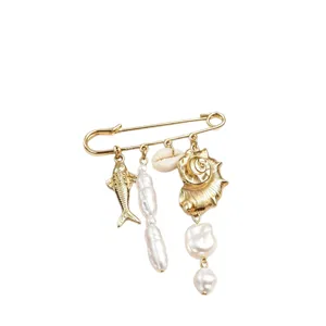 Broche épingle de sûreté dorée avec pendentifs coquillage perle et poisson style plage.