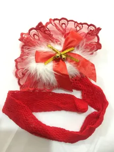 Detailed view of red fishnet stockings with lace, feathers, bow and bells for holiday wear.